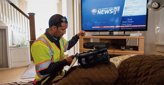 2015년 10월 타임워너 케이블 직원이 미국 뉴저지주 레오니아의 한 가정에서 고장 난 케이블TV를 수리하고 있다. 지난해 5월 차터 커뮤니케이션스는 타임워너 케이블을 인수했다. <사진 : 블룸버그>