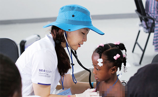 세아상역의 아이티 의료봉사활동이 열린 아이티 현지에서 의료진이 아이티 어린이를 진료하고 있다.