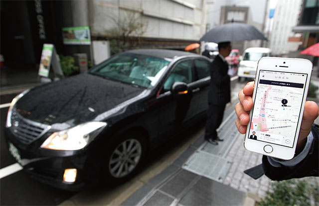 일본 도쿄에서 우버 재팬 직원이 우버 앱으로 차량을 호출하는 시범을 보이고 있다. 우버는 행동경제학을 이용해 수익을 증대시키고 있다. <사진 : 블룸버그>