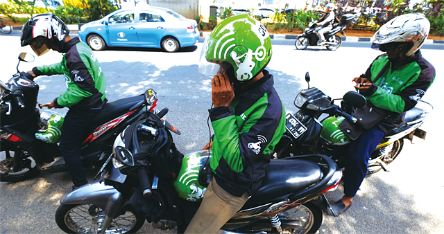 인도네시아 자카르타에서 고젝의 오토바이 기사들이 주문을 확인하고 있다. <사진 : 블룸버그>