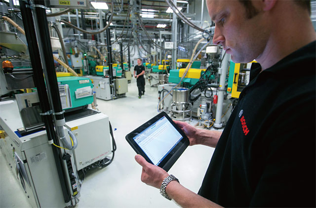 인더스트리 4.0을 활용한 독일의 보쉬 공장에서 노동자가 태블릿PC로 공장 가동 현황을 점검하고 있다. <사진 : 블룸버그>