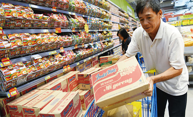 인도네시아 카라와치 지역의 한 수퍼마켓에서 한 남성이 인도푸드가 생산하는 라면 ‘인도미’를 박스째 쇼핑카트에 넣고 있다. <사진 : 블룸버그>