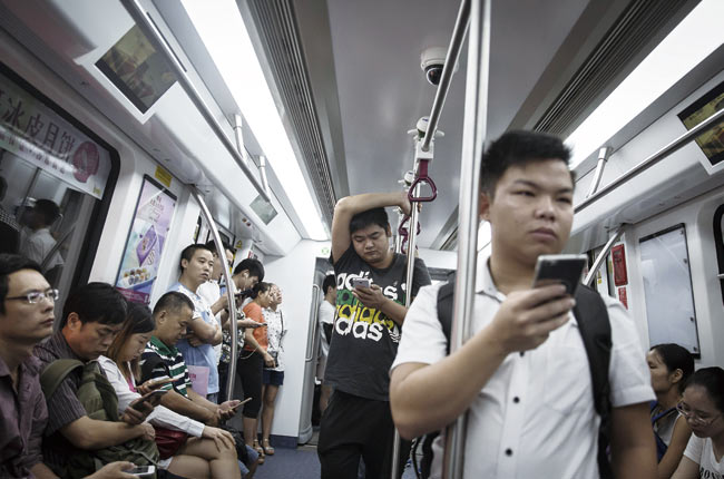 책은 온라인화의 핵심 요소로 인터넷, 데이터, 컴퓨팅 세 가지를 제시한다. 사진은 중국 선전 지하철에서 스마트폰을 보고 있는 승객들. 사진 블룸버그
