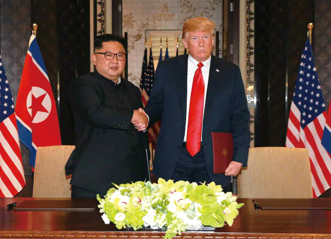 도널드 트럼프(오른쪽) 미국 대통령과 김정은 북한 국무위원장이 지난 12일 공동합의문에 서명한 후 악수하고 있다. 사진 연합뉴스