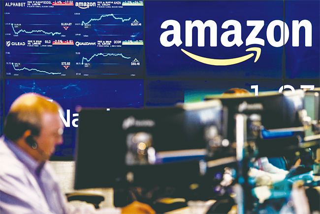 미 뉴욕 증권시장에서 나스닥 지수를 보여주는 화면에 유통 업체 아마존의 기업 로고가 떠 있다. 사진 블룸버그