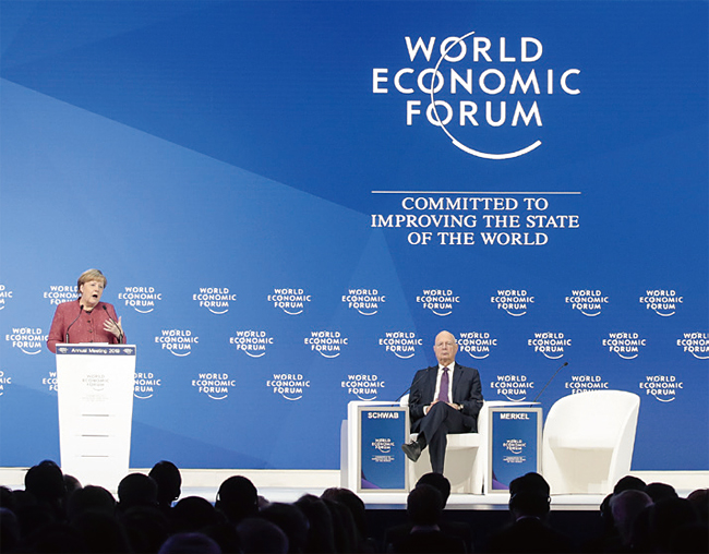 1월 23일(현지시각) 스위스 다보스에서 열린 세계경제포럼(WEF)에서 클라우스 슈밥(오른쪽) WEF 의장이 앙겔라 메르켈 독일 총리의 연설을 듣고 있다. 사진 블룸버그