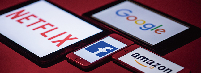 스마트폰과 태블릿PC에 표시된 구글, 아마존, 페이스북, 넷플릭스 로고. 사진 블룸버그