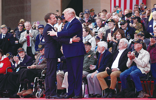 에마뉘엘 마크롱 프랑스 대통령(서 있는 두사람 중 왼쪽)과 트럼프 대통령이 프랑스 노르망디 미국 전사자 기념관에서 만났다. 사진 EPA 연합