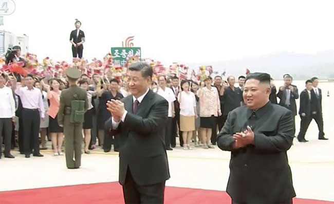 시진핑 중국 국가주석이 20일 평양 순안공항에 도착해 김정은 북한 국무위원장과 함께 환영 인파를 향해 박수를 보내고 있다. 사진 중국중앙방송국(CCTV)