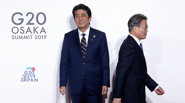문재인 대통령이 6월 28일 오전 인텍스 오사카에서 열린 G20 정상회의 공식환영식에서 의장국인 일본 아베 신조 총리와 악수한 뒤 이동하고 있다. 사진 연합뉴스