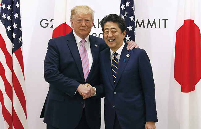 도널드 트럼프 미국 대통령과 아베 신조 일본 총리가 6월 28일 일본 오사카에서 열린 G20 정상회의에서 기념사진을 찍고 있다. 트럼프 대통령이 아베 총리 어깨에 손을 얹고 친밀함을 보였다. 사진 블룸버그