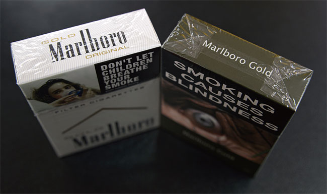 호주에서는 담배가 올리브색의 통일된 담뱃갑에 커다란 경고문구와 사진이 인쇄돼 판매된다. 사진은 필립 모리스 인터내셔널(PMI)의 말보로 골드 패키지. 왼쪽은 담뱃갑이 통일되기 이전의 모습. 사진 블룸버그