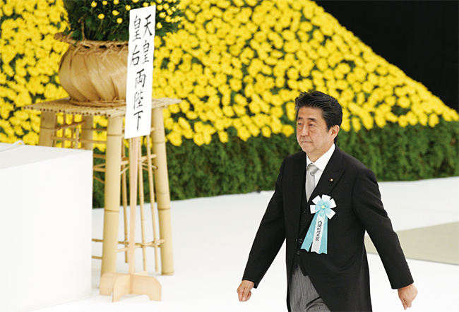 아베 신조 일본 총리가 일본 패전일인 8월 15일 도쿄 지요다구 부도칸에서 열린 전국전몰자추도식에 참석, 추모 헌화를 하려고 걸어가고 있다. 사진 AP연합뉴스