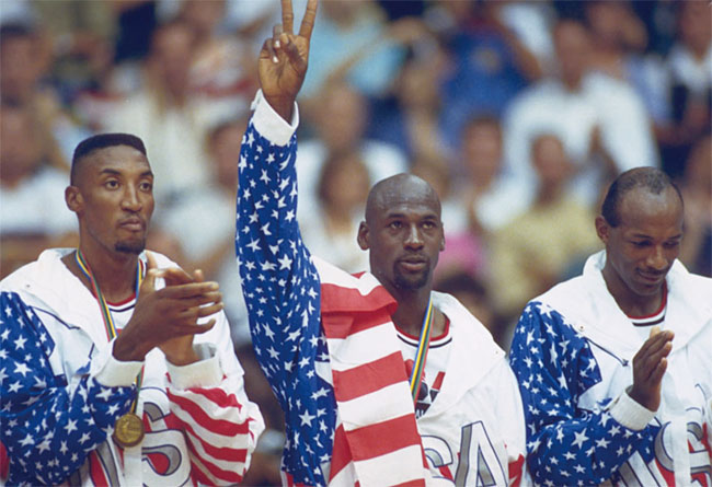 ‘농구 황제’ 마이클 조던(가운데)이 1992년 바르셀로나 올림픽 남자 농구에서 금메달을 딴 후 어깨에 성조기를 걸친 상태로 시상대에 오르고 있다. 사진 국제올림픽위원회(IOC)