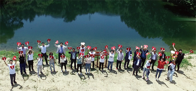 산본마을, 관동마을 주민과 저수지 사업을 시행한 한국 코카콜라 관계자, 한국생태환경연구소 관계자들이 산본마을 저수지에서 환호하고 있다. 사진 한국 코카콜라