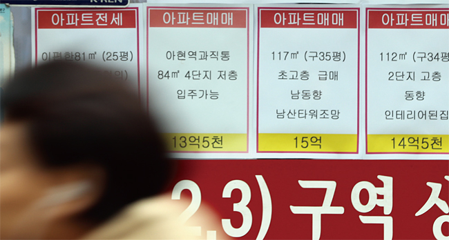 정부가 ‘12·16 주택 시장 안정화 방안’을 발표한 다음 날인 12월 17일, 한 시민이 서울 마포구의 공인중개사무소 앞을 지나고 있다. 사진 연합뉴스