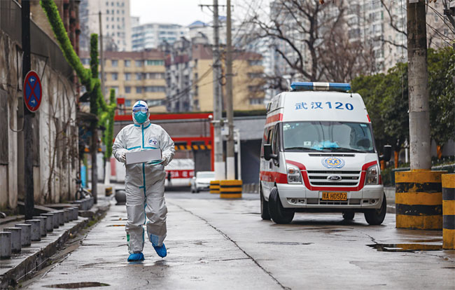 1월 26일 중국 허베이성 우한의 한 병원에서 방호복을 착용한 구급차 운전사가 의료 기기 상자를 옮기고 있다. 사진 EPA연합