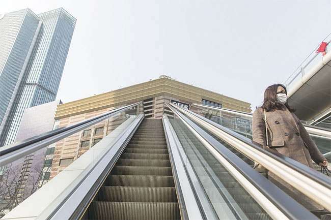 2월 3일 한산한 중국 상하이의 금융지구에서 마스크를 쓴 사람이 에스컬레이터를 타고 있다. 사진 블룸버그