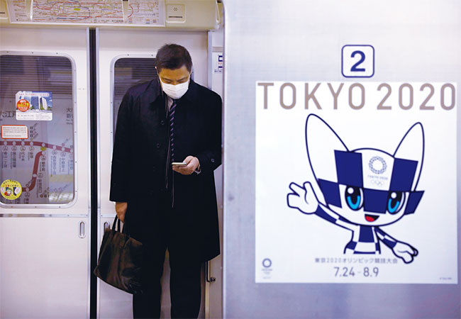 1월 31일 일본 도쿄의 한 지하철 출입문 옆에 ‘TOKYO 2020’이라고 쓰인 올림픽 포스터가 붙어 있다. 일본에서는 최근 중국에서 발발한 코로나19의 확산 우려 때문에 7월 24일 개막하는 도쿄 올림픽이 취소 혹은 연기될지 모른다는 루머가 퍼졌다. 도쿄올림픽조직위원회는 그럴 가능성을 부정했다. 사진 AP연합