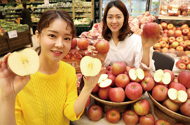 모델들이 서울 이마트 성수점 과일 매장에서 기존 제품보다 40% 저렴한 ‘보조개 사과’를 소개하고 있다. 사진 연합뉴스