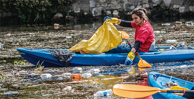 카약을 탄 자원봉사자가 이집트 나일강을 떠다니는 플라스틱 용기들을 수거하고 있다. 사진 AFP연합