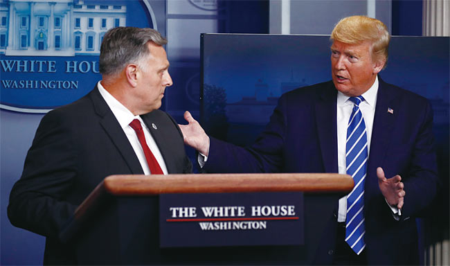 도널드 트럼프(오른쪽) 미국 대통령이 4월 23일(현지시각) 백악관에서 열린 코로나19 브리핑에서 빌 브라이언 국토안보부 과학기술국장에게 질문하고 있다. 사진 AP연합
