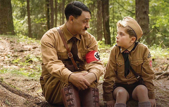 히틀러는 시시때때로 조조 앞에 나타나 함께 놀고 이야기하고 고민을 나눈다. 조조의 상상 속 친구이다 보니 히틀러의 수준도 아이의 한계를 벗어나진 않는다. 사진은 주인공 조조(오른쪽·로만 그리핀 데이비스)가 상상 속 히틀러와 대화하는 장면. 사진 IMDB