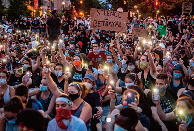 6월 3일(현지시각) 미국 워싱턴 D.C. 백악관 앞에서 조지 플로이드 사망 사건에 항의하는 시민들이 휴대폰의 조명을 밝히며 시위하고 있다. 사진 AP연합