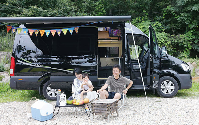 캠핑카의 그늘막을 펼친 가운데 가족이 캠핑을 즐기는 모습. 사진 조선일보 DB