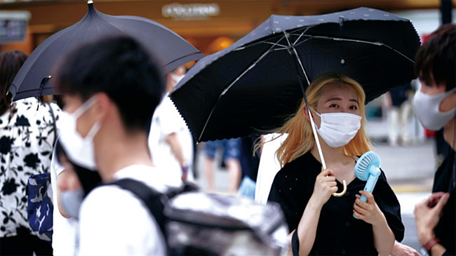 일본 도쿄 번화가인 시부야에서 8월 13일 마스크를 쓴 행인들이 길을 걷고 있다. 사진 AP연합