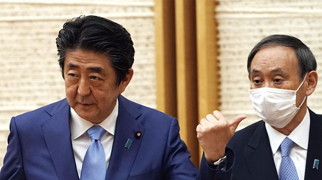 기자회견 후 아베 신조(왼쪽) 일본 총리가 스가 요시히데 일본 관방장관을 가리키고 있다. 사진 블룸버그