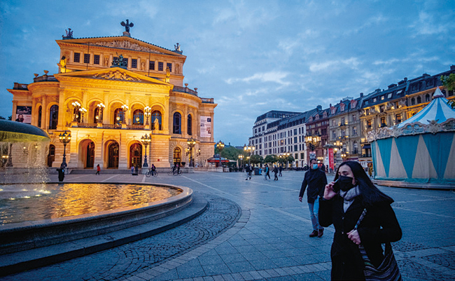 마스크를 쓴 여성이 독일 프랑크푸르트 올드 오페라 앞을 지나고 있다. 사진 AP연합