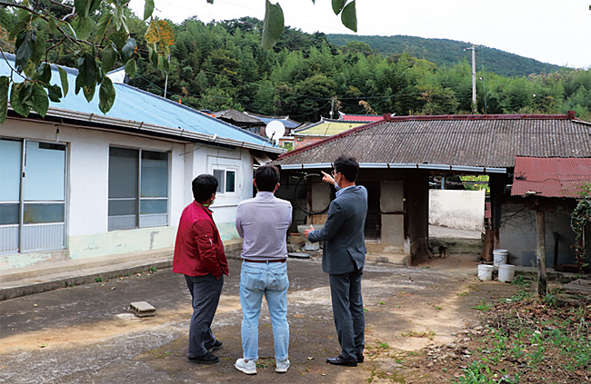 남해군 고현면에 있는 관당마을에서 마을 이장, 다자요 대표, 군청 관계자(왼쪽부터)가 빈 집을 보며 사업에 관해 이야기 나누고 있다. 사진 김지욱 인턴기자