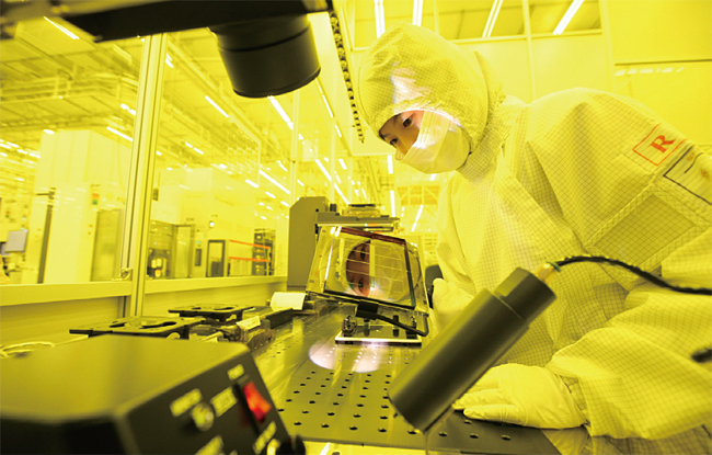 삼성전자 반도체 엔지니어가 회로가 새겨진 포토마스크를 확인하고 있다. 사진 삼성전자