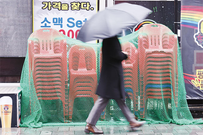 11월 30일 서울 종로의 식당가에 한 주점이 내놓은 간이 의자가 쌓여 있다. 위드 코로나 정책으로 잠시 회복세를 보이던 자영업이 다시 위축될 것으로 우려된다. 사진 연합뉴스