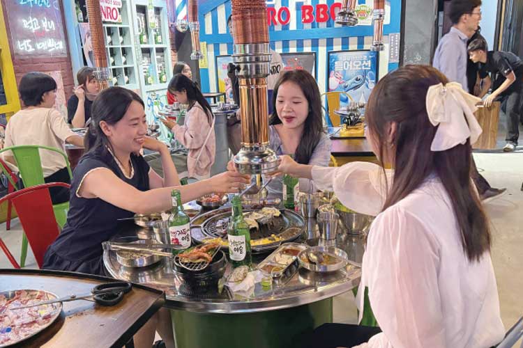 Local consumers drinking fruit soju at a Jinro BBQ store near Ta Hien Beer Street in Hoan Kiem District, Hanoi, Vietnam on June 10. / Hanoi Joint Reporting Team