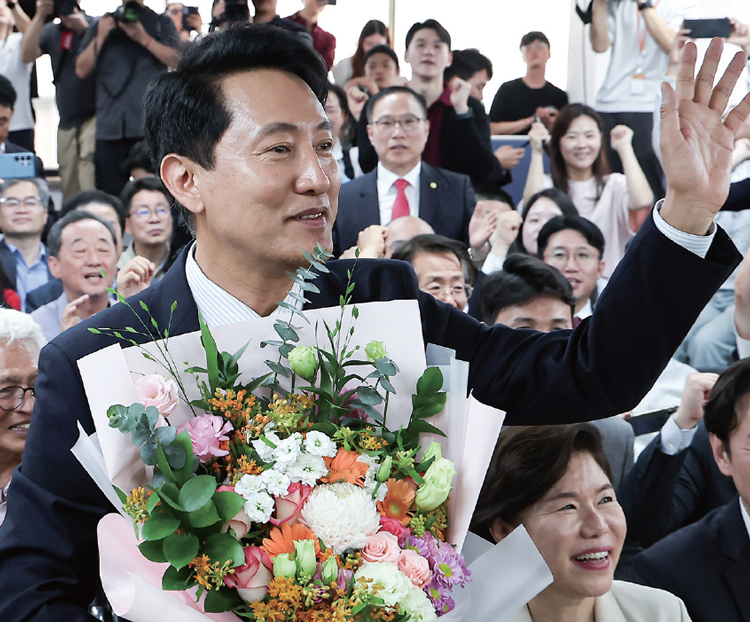 6·3 지방선거에서 당선된 오세훈 국민의힘 서울시
장 당선자가 6월 4일 서울 종로구 선거사무소에서
꽃다발을 전달받고 손을 흔들고 있다. /사진 뉴스1