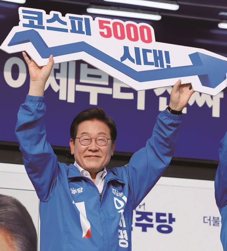 이재명 대통령이 2025년 5월 후보 시절 '코스피 5000 시대'가 적힌 피켓을 들고 있다. /사진 뉴스1 